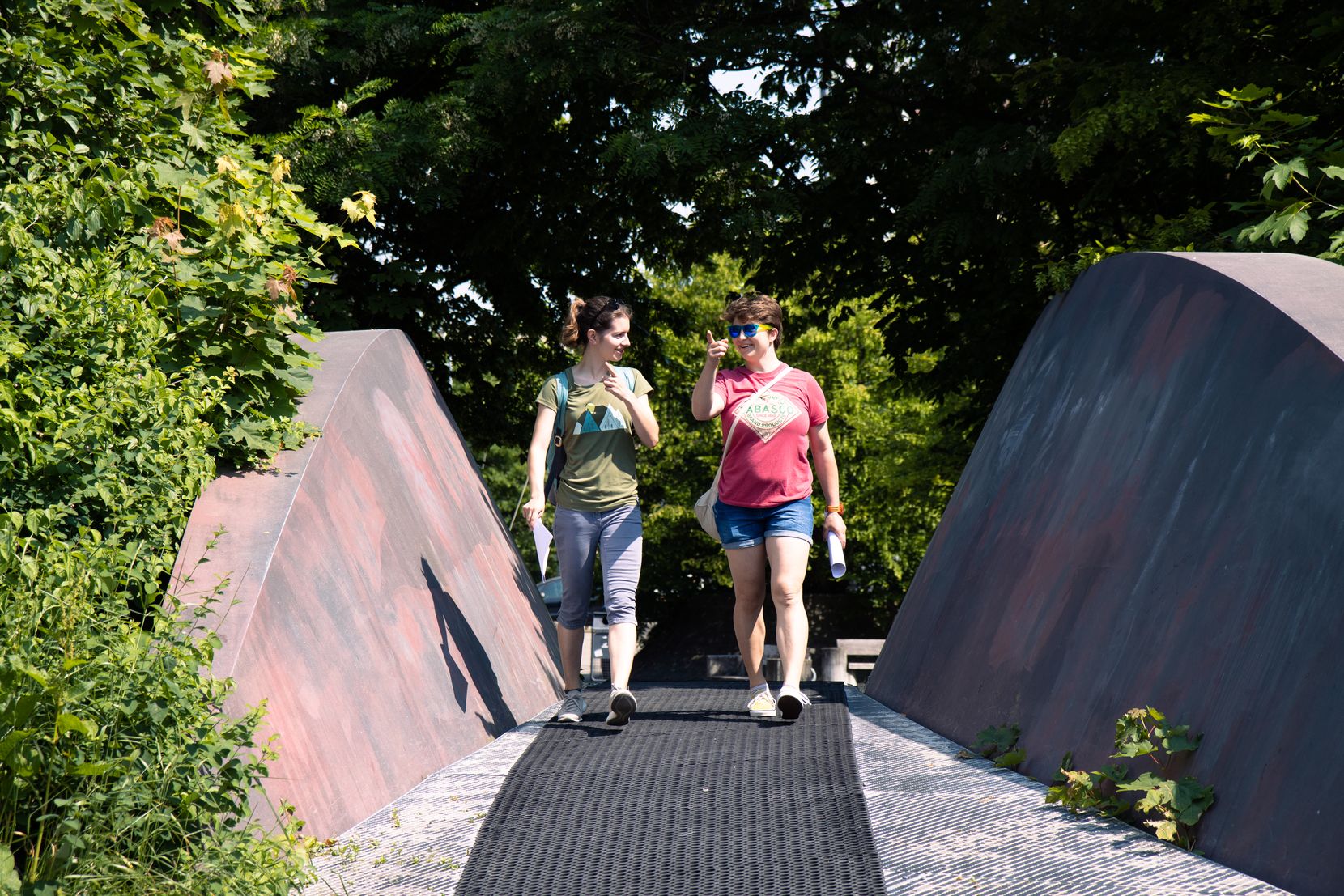 Zwei junge Frauen laufen über eine Brücke.